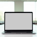 A laptop with a blank screen on a table in a bright room