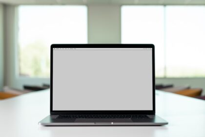 A laptop with a blank screen on a table in a bright room
