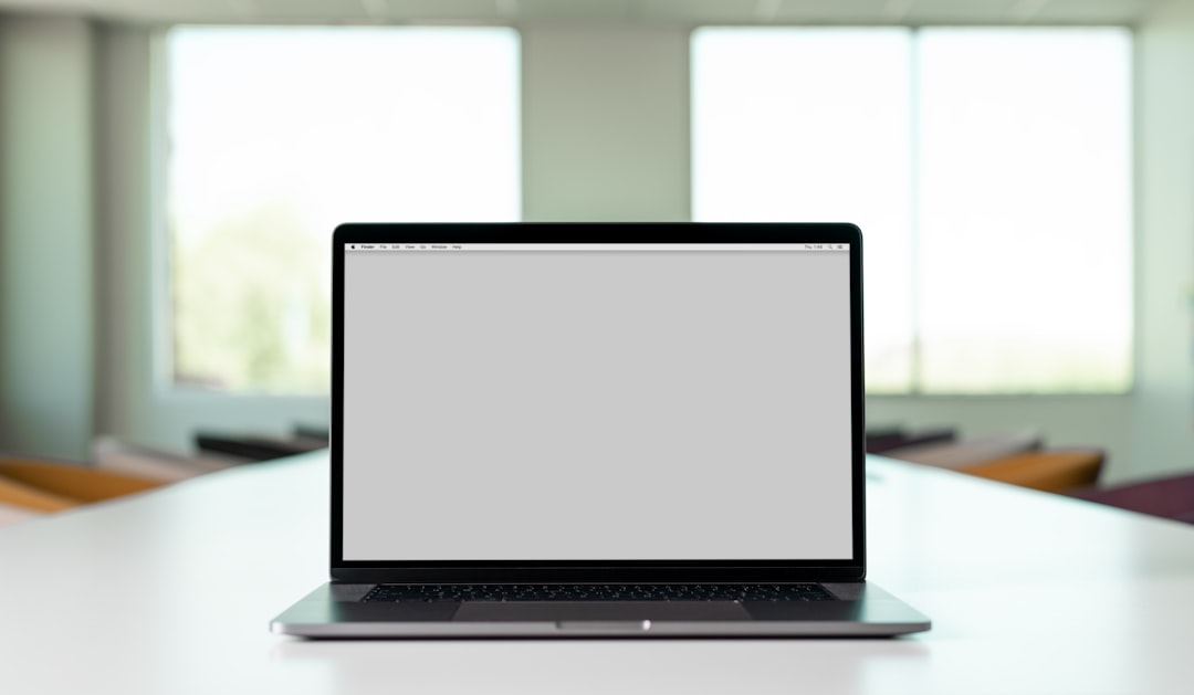 A laptop with a blank screen on a table in a bright room